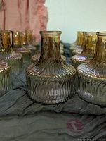 Front view of several matching ribbed glass bud vases showing shape, texture, and color