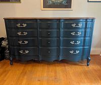 Full frontal view of dark green-blue serpentine dresser showing 12 drawers, wooden top, ornate pulls, cabriole feet