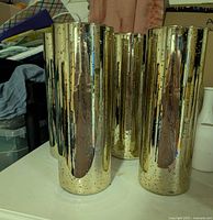 Four gold mercury-glass cylinder vases grouped