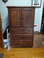 Front view showing doors and three drawers