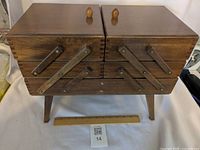 Front view of wooden cantilever sewing box closed
