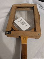 Full racket secured in wooden press