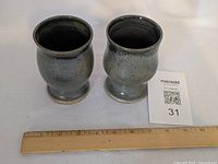 Both ceramic goblets side by side with ruler and lot card for scale
