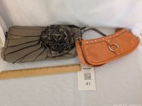 Both purses side by side with ruler for scale