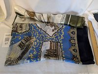 Both scarves folded, showing patterns and ROMA text