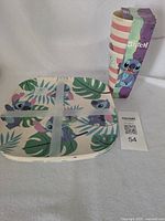 Stacked plates and boxed tumblers showing Stitch designs