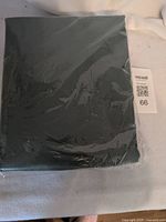 Front view of sealed dark green sheet set package with lot tag
