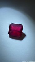 Emerald cut ruby front view under spotlight
