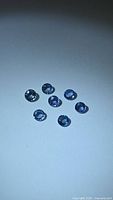 Seven round blue sapphires on white background