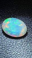 Top view of oval faceted Ethiopian opal showing multicolour play-of-colour