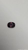 Front view of oval purple sapphire showing facets and colour