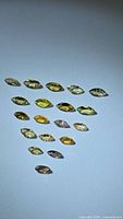 Multiple marquise-cut yellow-orange gemstones shown to illustrate cut and color; one 2.11ct stone offered