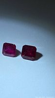 Two octagon cut rubies on light background