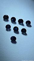 eight faceted deep blue sapphires on neutral background