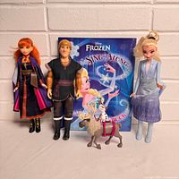 Group shot of Elsa, Anna, Kristoff dolls, Sven and Olaf figures, and Frozen Sing-Along book