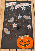 Full view of advent calendar showing entire design, numbers 1-31, movable spider, pumpkin base