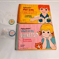 Front covers of both cloth books with two tokens beside