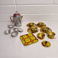 Group shot of entire lot showing percolator, silver pans, patterned cups, tray and lid