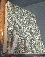 Worn green-white marbled paper slipcase with torn edge