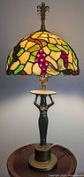 Full view of lamp showing stained glass shade and figural base