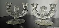 Pair of clear glass double-arm candleholders front view