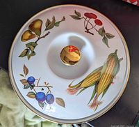 Top view of lid showing fruit and vegetable motifs and gold finial