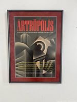 Full view of framed Ártrópolis poster on wall showing mat and frame