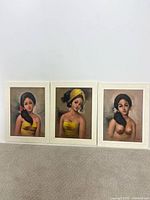 All three framed Balinese portrait paintings side by side
