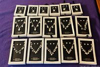All 16 boxed crystal necklace and earring sets arranged in four-by-four grid