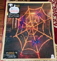 Front of box showing Member's Mark 7.5 ft Pre-Lit Twinkling Spider Web image