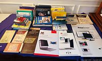 Overall view of assorted books and three boxed privacy screen filters displayed on table