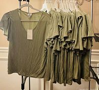 Rack showing one shirt front and stack of additional shirts