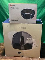 Retail boxes of Miko foot massager and Lifepro AllevaRed belt