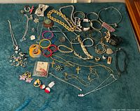 Wide shot all costume jewelry pieces on teal surface