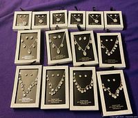 All 14 boxed crystal necklace and earring sets displayed