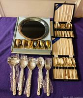 Full lot showing spoons in cases, goblets with tray, serving utensils