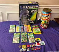 Group shot of all items showing puzzle box, log tin, TMNT clock, stickers, pins
