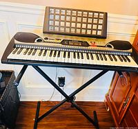 Front view of Yamaha EZ-20 keyboard on X stand with music rest