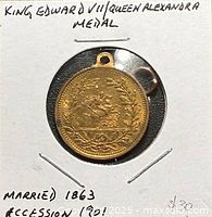 Obverse of brass coronation medal showing wreath design and suspension loop