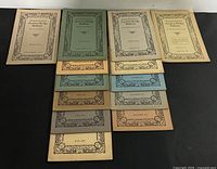 All 11 Auction Bridge Bulletins laid out showing range of cover colours and months