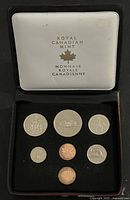 Open display case showing all seven coins in holder