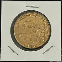 Obverse of bronze Aloha Dollar coin displaying Hawaiian Islands, airplane, King Kamehameha statue and legends.