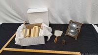 Overview of lot with boxed pocketbook, mirrors, brass piece and ruler