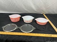 Overview of three casseroles and two lids with rulers for scale