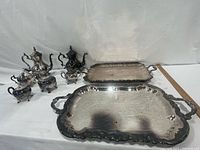 Group shot showing two five-piece tea sets and two trays