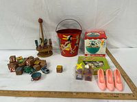 Full lot overview showing boxed Chime Ball, Loop Craft kit, tin pail, wooden carousel, blocks, cars, cup, shoes