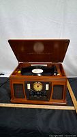 Wooden Victrola turntable console open with record on platter