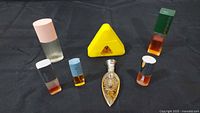Group shot of seven assorted perfume bottles on black background