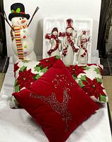 Group shot of standing snowman, ceramic snowman set in foam tray, three pillows