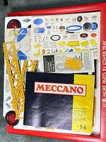 Top tray with yellow girders, blue discs, wheels, decal sheet and booklet